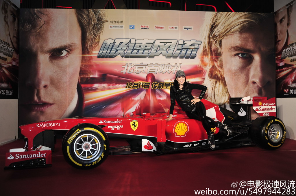 A Chinese fan poses atop a Rush promotional car. 